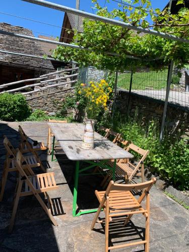 a picnic table with chairs and a tea kettle on it at Ca da Viola in Cavagnago
