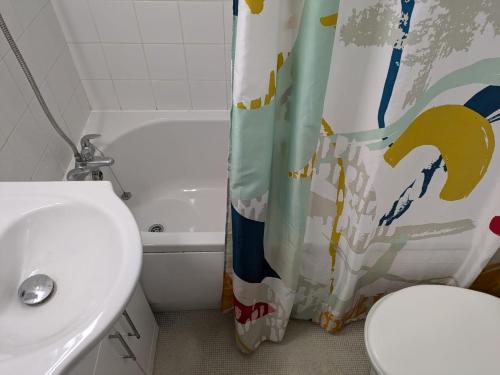 ein Badezimmer mit Toilette und Duschvorhang in der Unterkunft Coventry Central Craven Rooms in Spon End