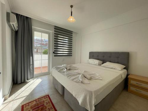 Un dormitorio con una cama grande y una ventana en Symbola Apartment 2 bedrooms in Hisaronu, en Fethiye