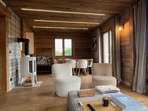 a living room with a fireplace and a table and chairs at Chalet Taïga in Combloux