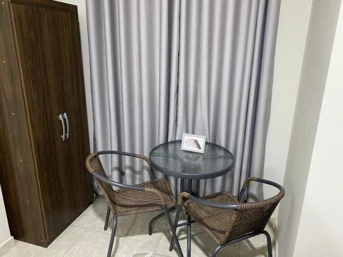 a glass table with two chairs and a plate on it at Mablia Suite in Ica