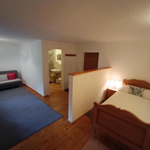 a bedroom with a bed and a bathroom with a sink at Michls Hoamat Dreibettzimmer in Sölden