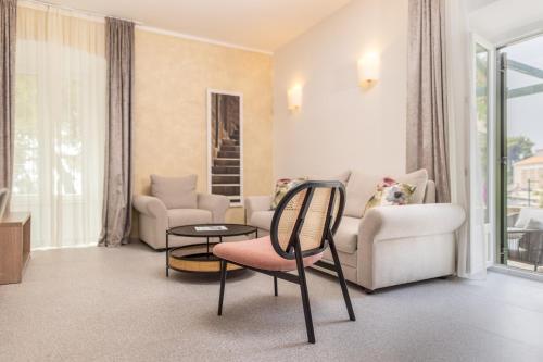 a living room with a couch and a table and chairs at Maistra Select Mlini Hotel in Mlini