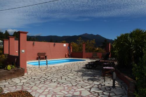 patio z basenem ze stołem i krzesłami w obiekcie Casitas La Montañita w mieście El Paso