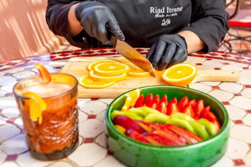 una persona che taglia le verdure con un coltello su un tagliere di Riad Itrane a Marrakech