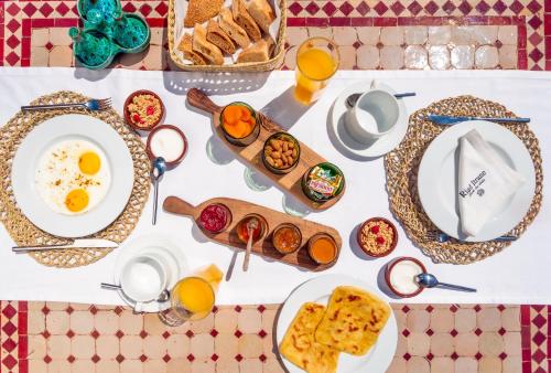 un tavolo con piatti per la colazione e succo d'arancia di Riad Itrane a Marrakech