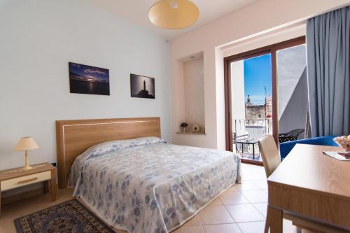 sypialnia z łóżkiem, stołem i oknem w obiekcie B&B Soli D'oro w mieście Casarano