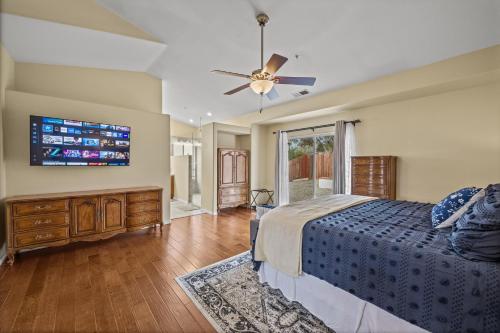 a bedroom with a bed and a flat screen tv at Explore Ramonas Vineyards Tranquil Home with Yard in Ramona