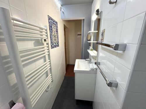 une salle de bain blanche avec un lavabo et un miroir dans l'établissement ApartHotel Riviera - VINCENT 1 - Vieille Ville - Appartement Supérieur 2 pieces AC, à Nice