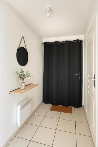 une pièce avec un rideau noir et un sol carrelé dans l'établissement T3 cosy avec jardin et parking, calme et nature, à Bouchemaine