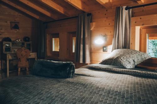 a bedroom with a bed in a wooden cabin at Chalet familial d'exception - Foux d'Allos in Allos
