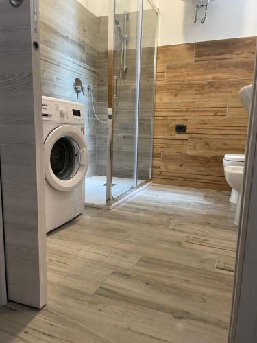 a bathroom with a washing machine and a shower at La Maison di Vicolo Torre in Uboldo