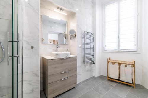 une salle de bain avec un lavabo et une douche en verre dans l'établissement Sunlight Properties - Archibald - Nice Port area, 2 Bedrooms, stunning holiday rental apartment with balcony & parking, à Nice