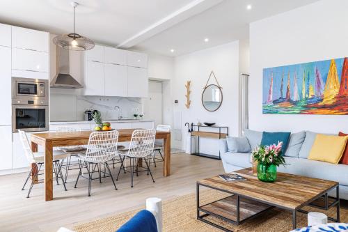 une cuisine et un salon avec une table et un canapé dans l'établissement Sunlight Properties - Archibald - Nice Port area, 2 Bedrooms, stunning holiday rental apartment with balcony & parking, à Nice