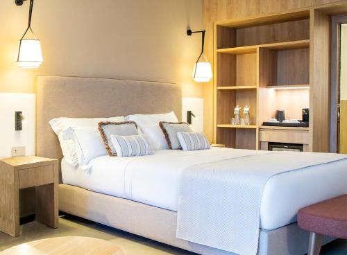 a bedroom with a large white bed with two pillows at Mangia's Sardinia Resort - NEW OPENING in Santa Teresa Gallura
