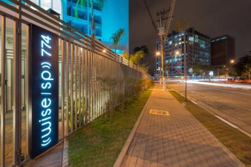 a sign on the side of a building next to a street at Studio near MetrôTietê, Anhembi and EXPO in Sao Paulo