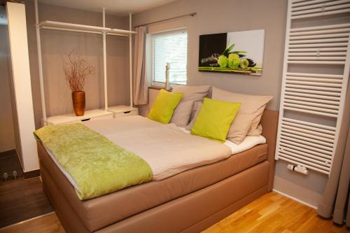 a bedroom with a bed with yellow pillows and a window at WohnRaum Gäste- & Boardinghaus in Gusterath