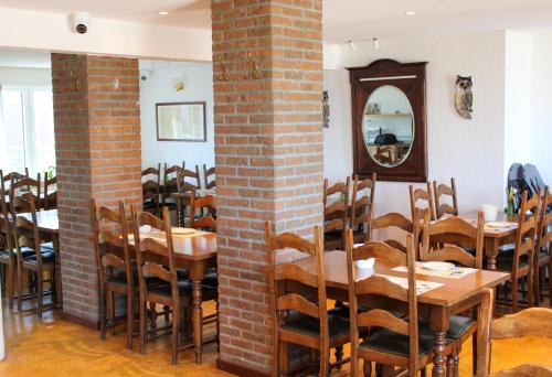 a dining room with tables and chairs and a mirror at Hotel Uilenspiegel in Nieuwpoort