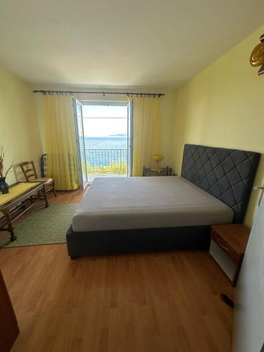 a bedroom with a large bed and a large window at Apartment Varga in Sveti Juraj
