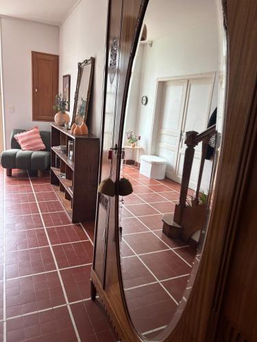 un miroir dans un salon avec un sol carrelé dans l'établissement Maison Mère, à Arnac-Pompadour