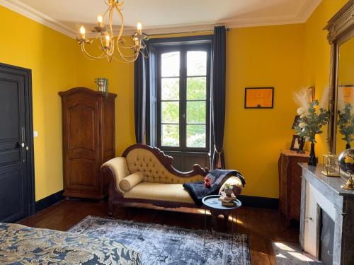 a living room with a couch and a dog laying on a table at La Maison de Maître Chagnon Aumagne in Aumagne