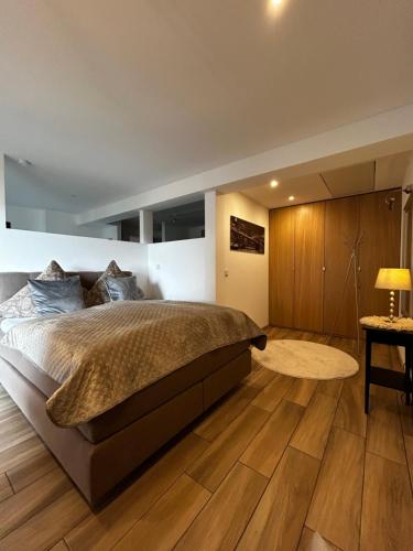 a bedroom with a large bed and wooden floors at WohnRaum Gäste- & Boardinghaus in Gusterath