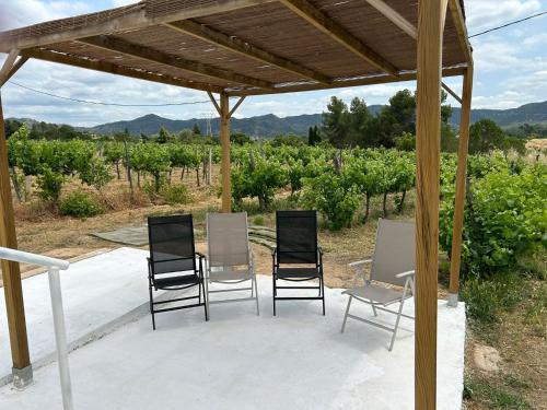 a group of chairs sitting under a pergola at La Caseta Vella in Falset