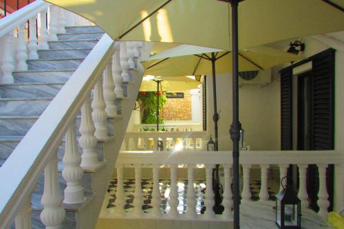 a white staircase with an umbrella in a house at Castellino Zwillingsstudios 1 in Kallithea Rhodes