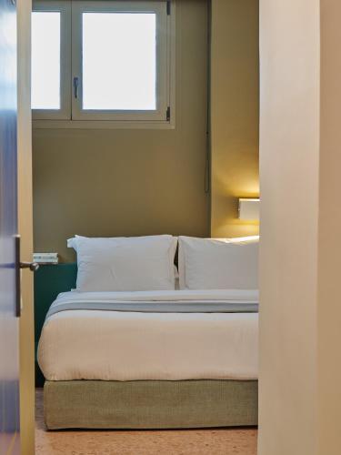 a bedroom with a bed and two windows at Nileos House in Athens