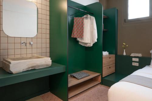 a green bathroom with a tub and a bed at Nileos House in Athens