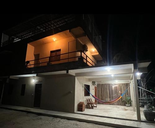a building with a balcony on the top of it at night at Pousada Zona do Kite Jeri in Jericoacoara