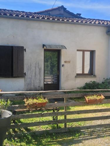 une maison avec une clôture en bois devant elle dans l'établissement Un rêve à faire, à Vinezac