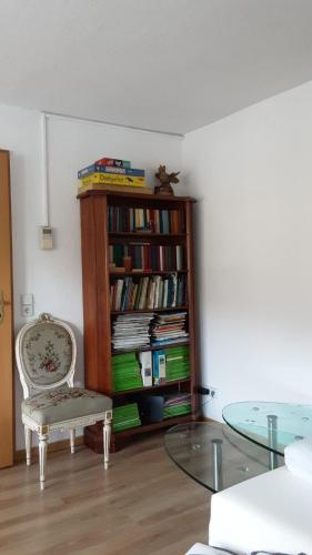 Una habitación con una estantería con libros y una mesa de cristal. en Renovierte Wohnung In Königstein, en Königstein