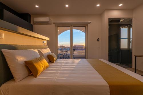 a bedroom with a large bed and a balcony at Floral Apartment in Castellammare di Stabia