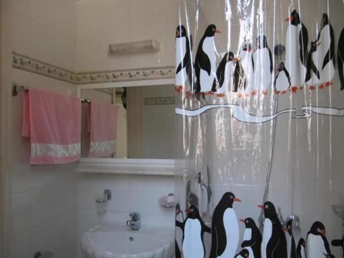 a bathroom with a bunch of penguins on a shower curtain at Castellino Studios in Kallithea Rhodes