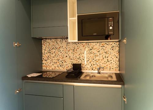 a kitchen with a sink and a microwave at Floral Apartment in Castellammare di Stabia