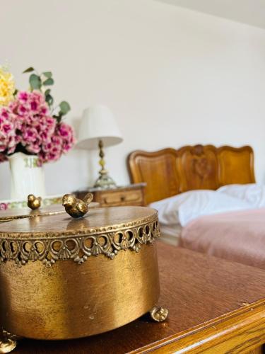 a gold tub sitting on a wooden table with flowers at Pod Katedrą in Drohiczyn nad Bugiem