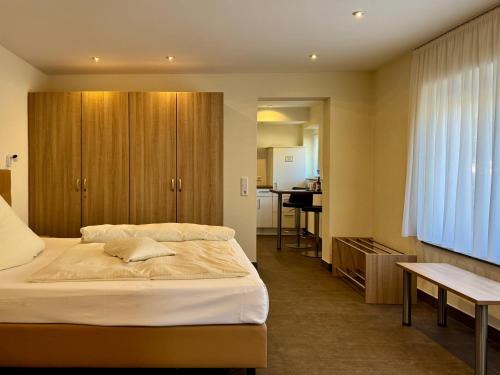 a bedroom with a large bed and a kitchen at Engelhard Das Landhotel Garni in Kirchheim am Ries