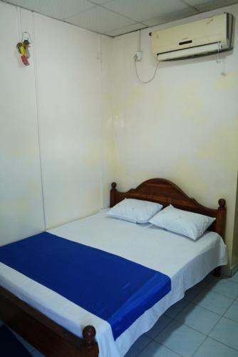 a bedroom with a bed with a blue blanket at Hotel Sella in Kilinochchi