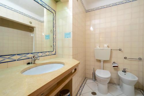 a bathroom with a sink and a toilet and a mirror at Bellavista Avenida By BeGuest in Albufeira