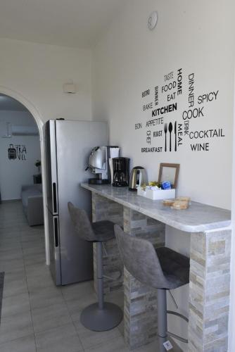a kitchen with a counter with chairs and a refrigerator at Carini Sant Anna in Carini