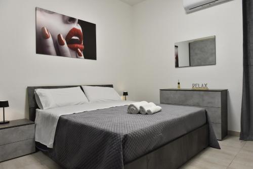 a bedroom with a bed and a painting on the wall at Carini Sant Anna in Carini