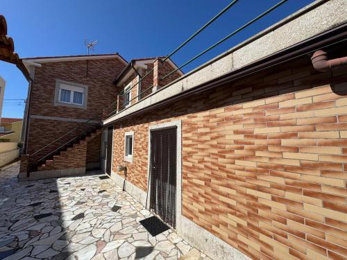 a brick building with a gate on the side of it at Casa Outeiro Polo 2 in Marinhas