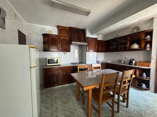 a kitchen with wooden cabinets and a table and chairs at Casa Outeiro Polo 2 in Marinhas
