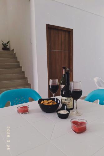 a table with a bottle of wine and two glasses at Casa Vianca Beach in Estación El Salto