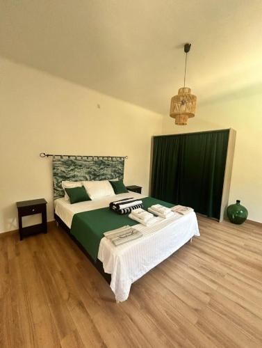 une chambre avec un grand lit avec une couverture verte dans l'établissement Fontaine de bonheur, à Fontaine-de-Vaucluse