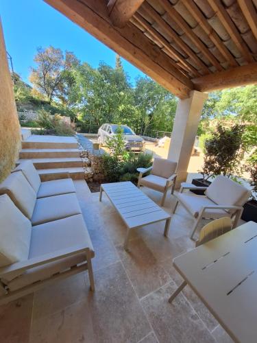 d'une terrasse avec un mobilier blanc et un toit en bois. dans l'établissement Fontaine de bonheur, à Fontaine-de-Vaucluse