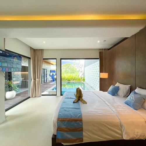 ein Schlafzimmer mit einem großen Bett mit einem Teddybär drauf in der Unterkunft Luxury Villa pemandangan sawah - fulton Regatta 3BR in Ngaglik