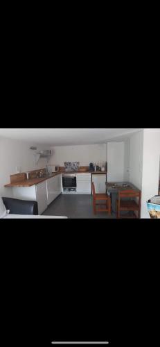 une cuisine avec des armoires blanches et une table et des chaises dans l'établissement Sunny 3-room house, à Saint-Malo