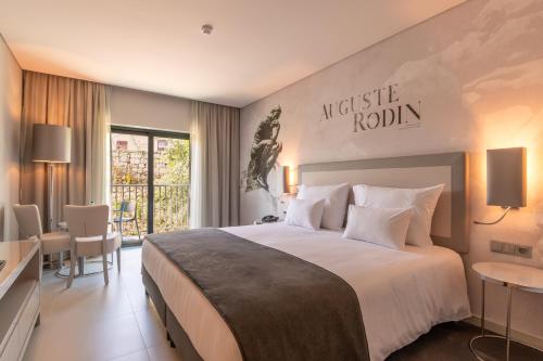a hotel room with a large bed and a table at Vila Gale Collection Ponte de Lima in Ponte de Lima